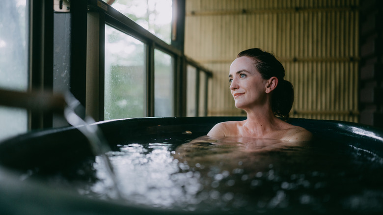 Woman enjoys a soak in an indoor hot tub