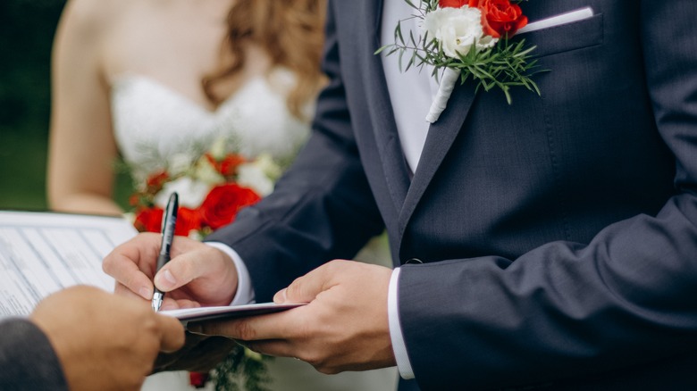 bride and groom signing a marriage certificate