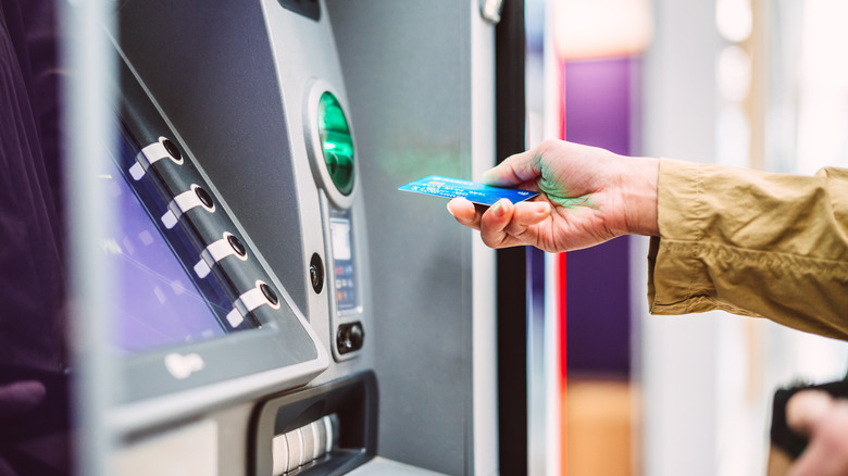 A woman inserting a card into the ATM machine