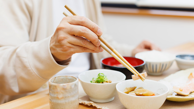 Person eating meal with chopsticks