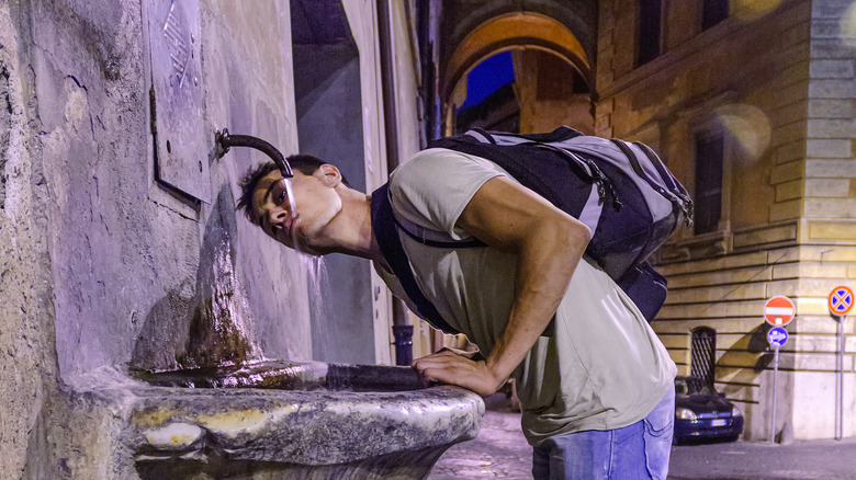 person using Italian drinking fountain