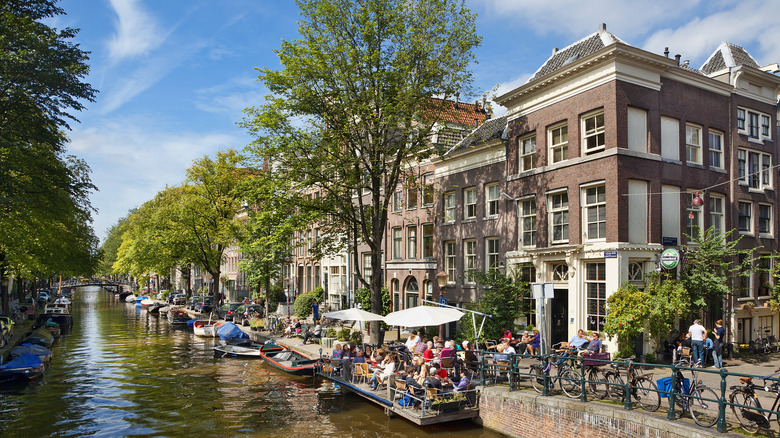 People lounging beside a canal in Amsterdam