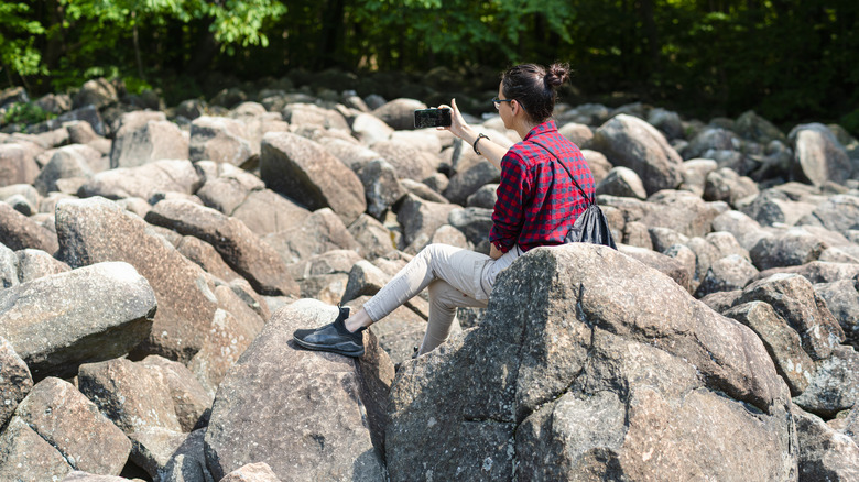 Woman sitting in field of ringing rocks