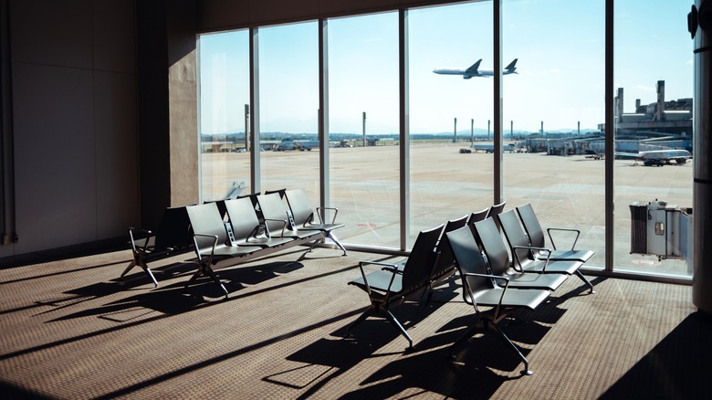 Empty airport seating area with plane in the background