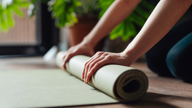 Person rolling up yoga mat