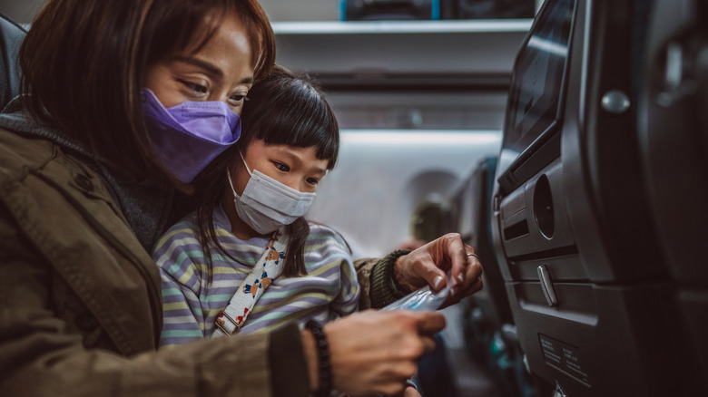 A mom opening wet wipes with a child on her lap