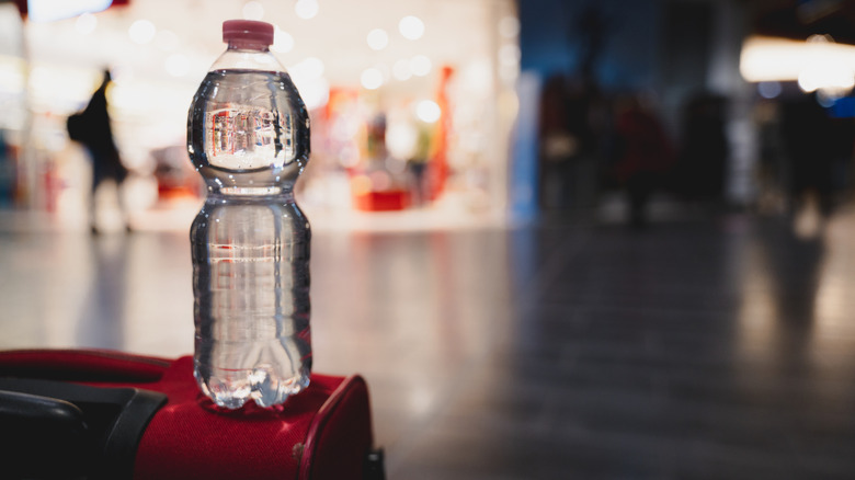 Water bottle sitting on luggage in an airport