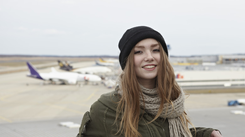 Woman wearing a beanie on her head while standing on tarmac