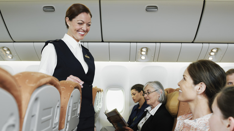 Flight attendant speaking to passengers on a flight