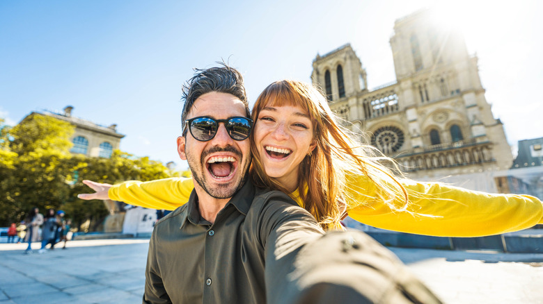 Man and woman posing in front of Cathédrale Notre-Dame de Paris