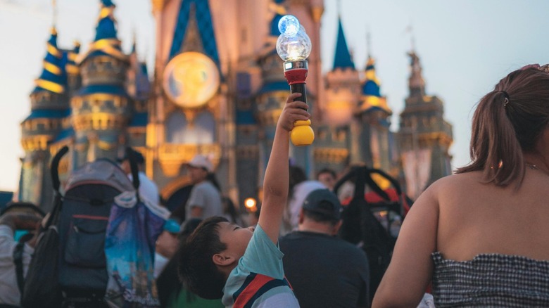 Family sitting in front of Cinderella's castle at Walt Disney World