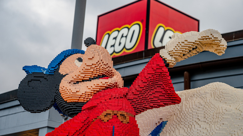 a Sorcerer's apprentice Mickey Mouse made of lego in front of a lego sign