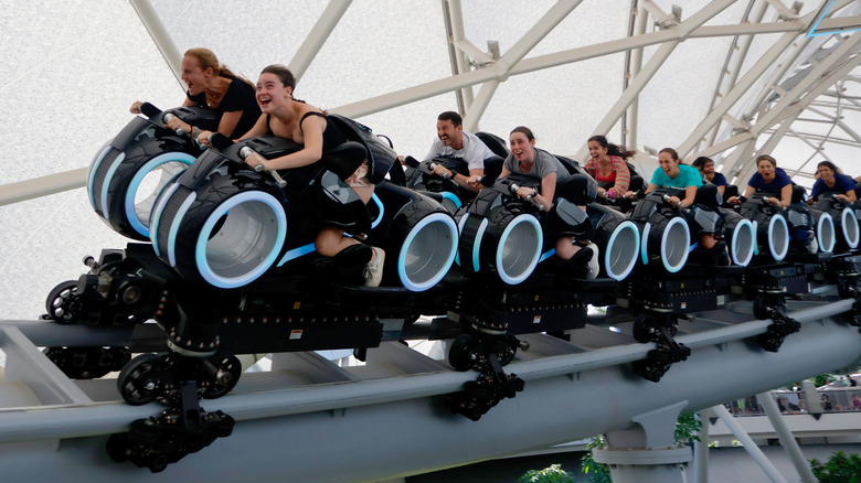 Disney vacationers riding on the Tron lightcycle