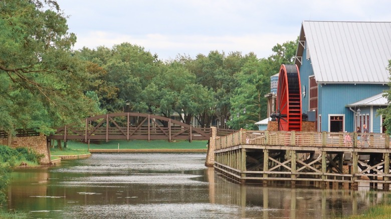 A wooden bridge and water wheel on a decorative manmade waterwayi at Walt Disney World Port Orleans resort