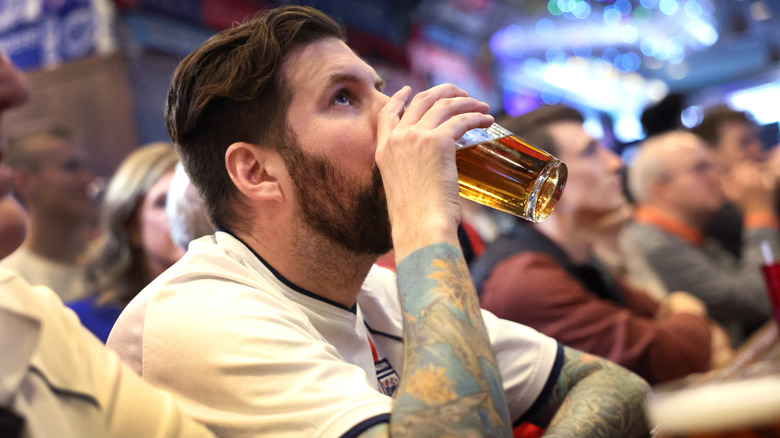 A man drinking a beer in a bar