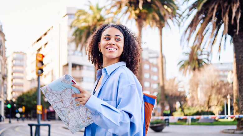 Female traveler exploring a new city with a map