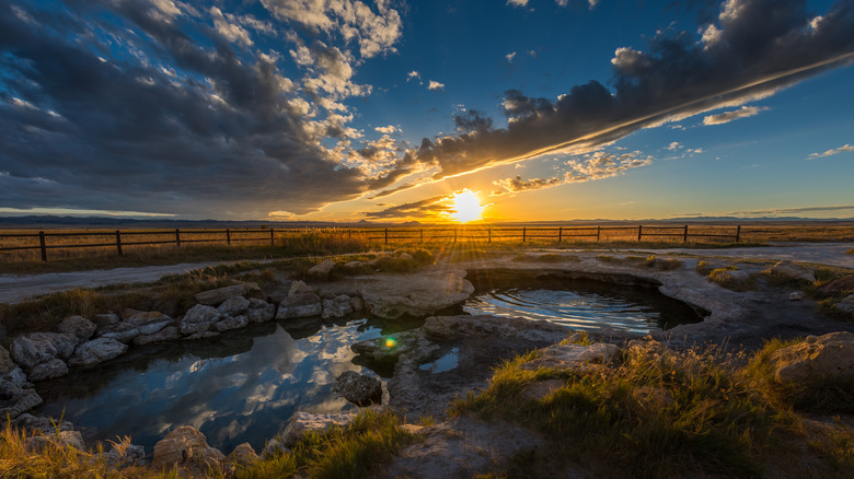 Meadow Hot Springs with the sun setting behind clouds