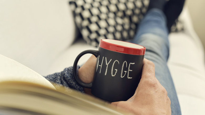 Man holding cup that says 'hygge'