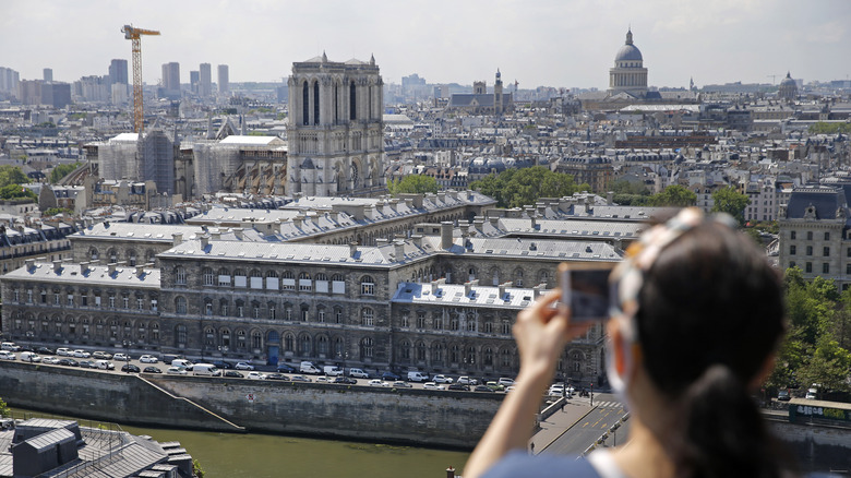 A tourist photographs Paris skyline