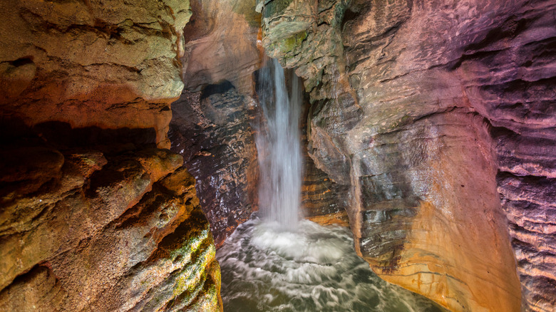 Italy's Cascata del Varone flowing into an illuminated rocky cave