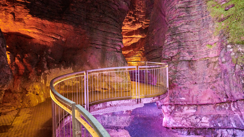 Inside the pink illuminated grottoes at the Cascata del Varone in Italy