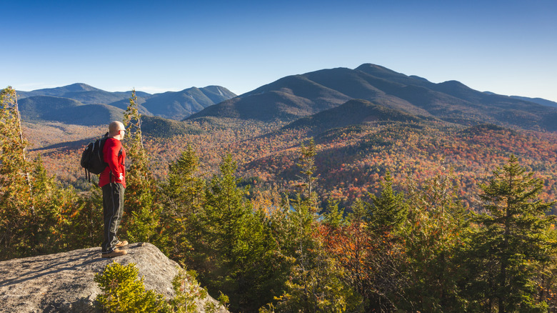 A hiker looks out at the Adirondack mountains