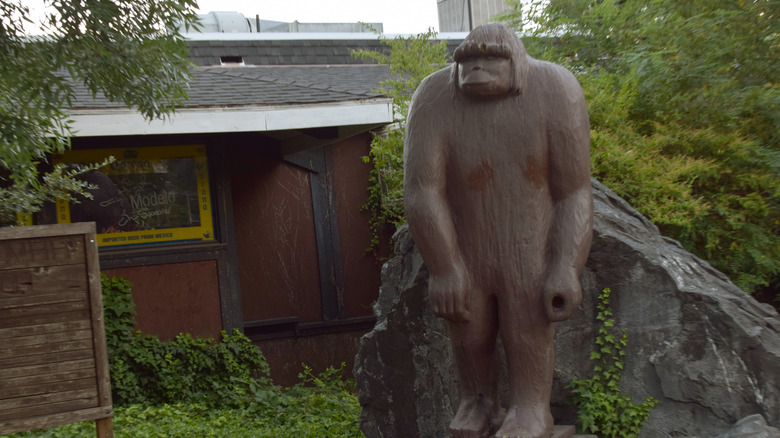 Bigfoot statue in front of house and forest