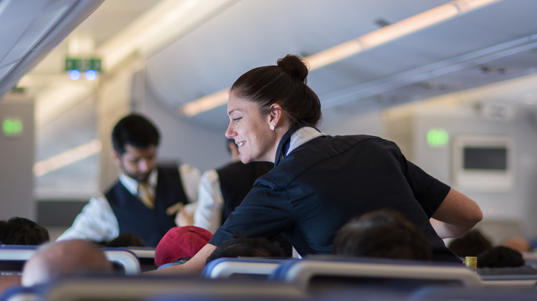 Flight attendants speaking to passengers 