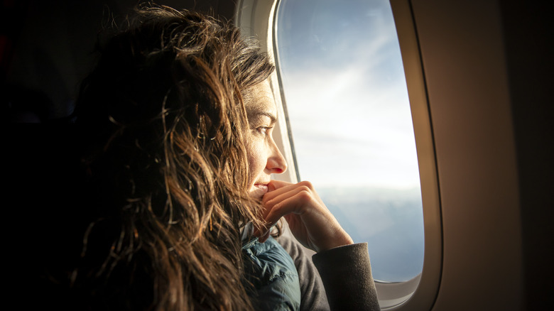 Woman looking out plane window