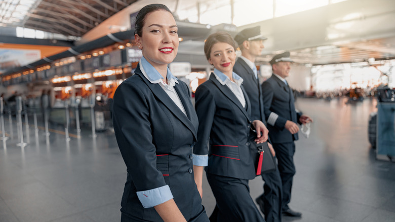 Flight attendants and pilots walking through an airport