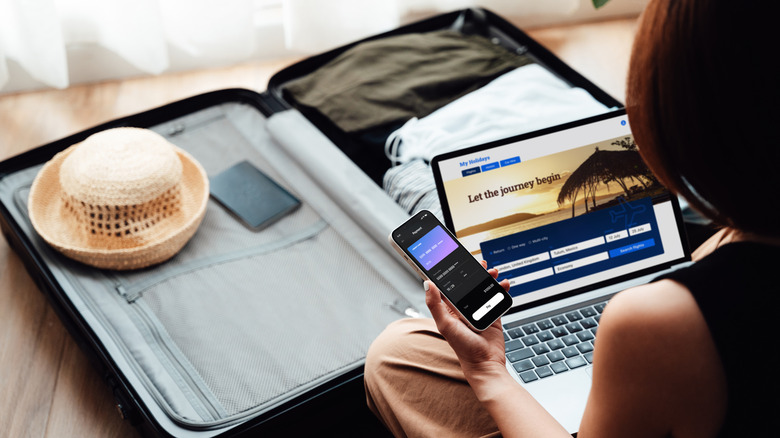 woman on laptop by luggage