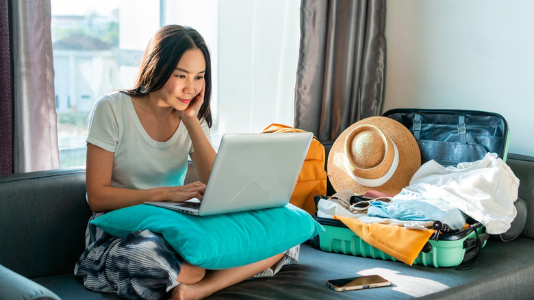 woman on laptop with luggage