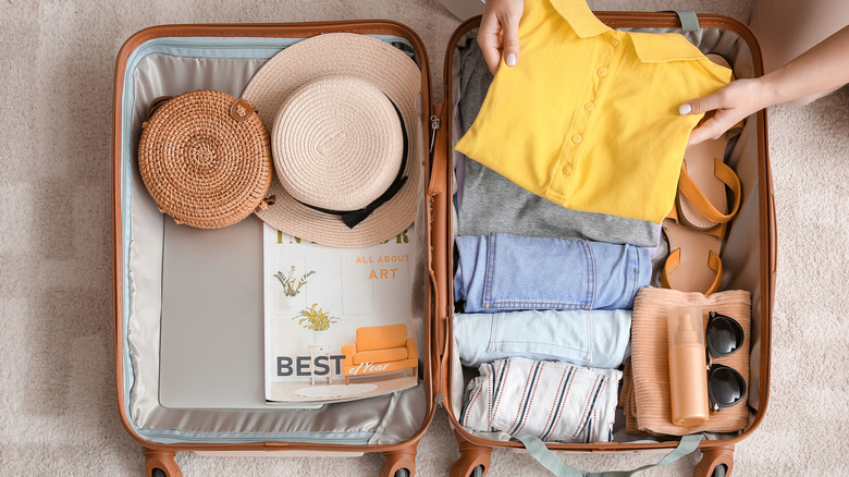 woman packing suitcase with clothes