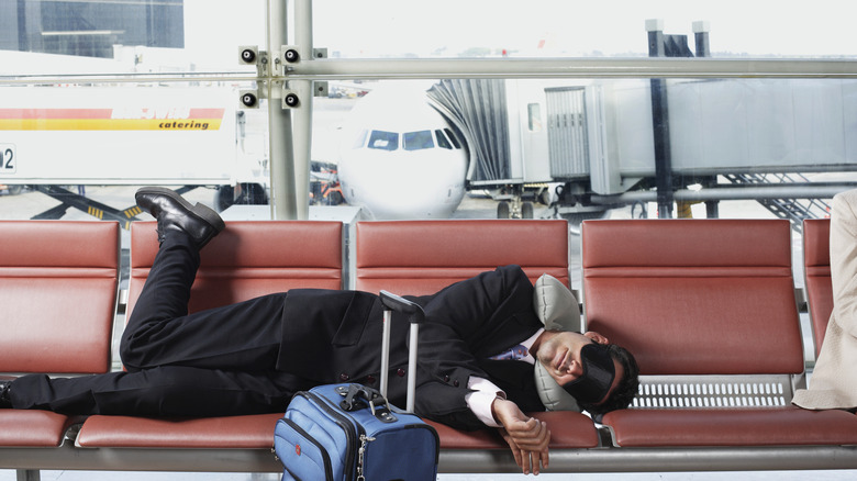 Man in suit sleeping at the airport