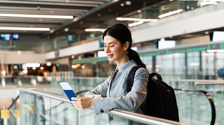 Woman with a passport and boarding pass at airport