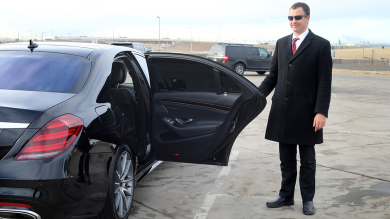 driver holds limo door open