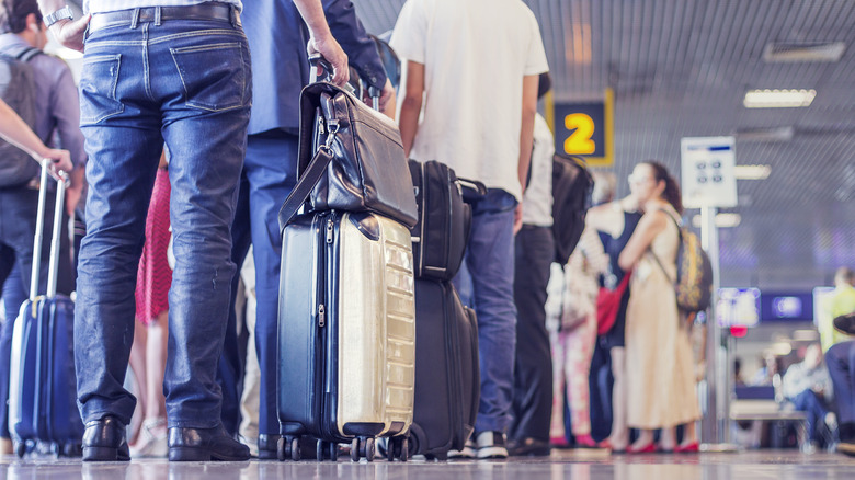 People in an airport line with luggage