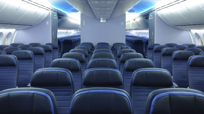 Rows of seating on an empty plane with three seats at the sides and in the middle