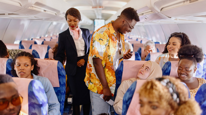 People finding their seats on a plane