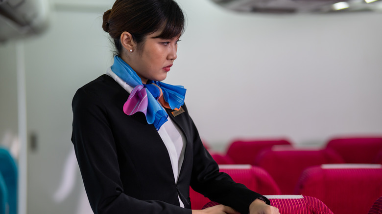 Flight attendant looking stressed on plane