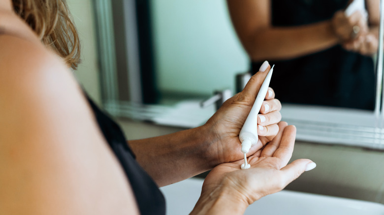 Woman applying lotion on her hand at a hotel