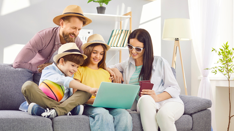 A family of four planning a trip in a living room