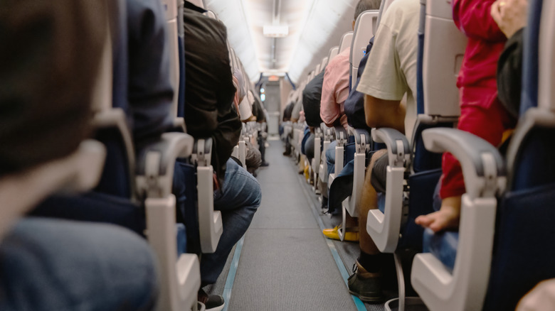 Aisle of plane with passengers seated on both sides