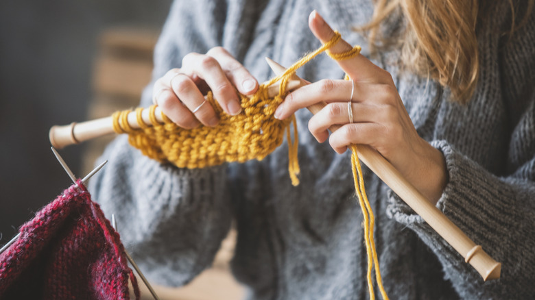 A person knitting with bamboo needles