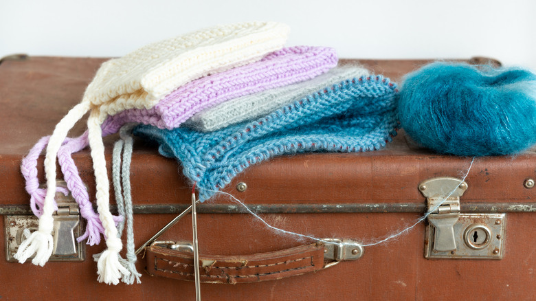 Knitted items and yarn on a suitcase