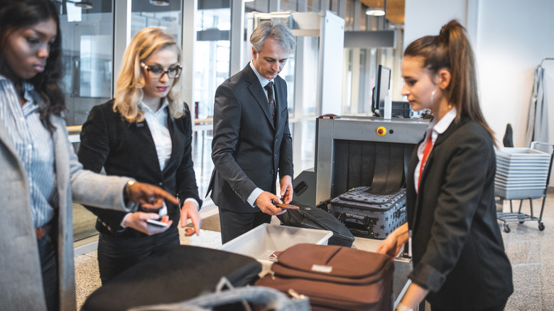 Woman's luggage being inspected at security check