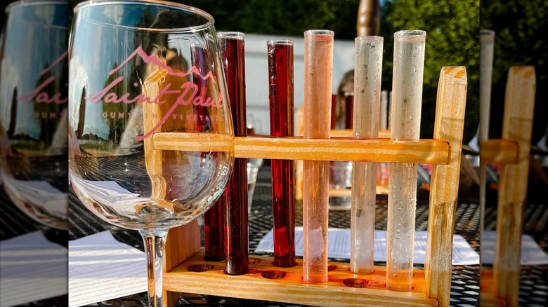 Wine glass with Saint Paul logo and tubes of different red and white wines