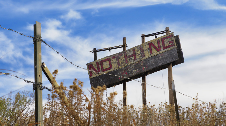 Sign of Nothing, Arizona, with barbed wire and desert grass