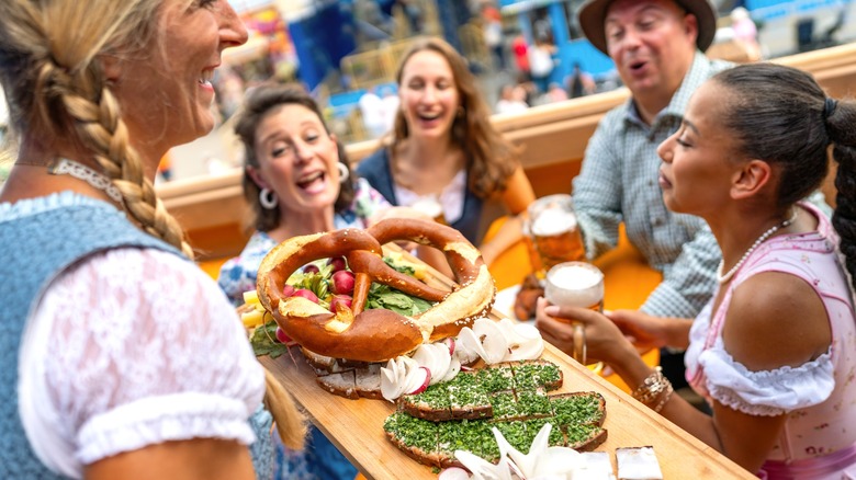 Waitress serving pretzels to beer drinkers