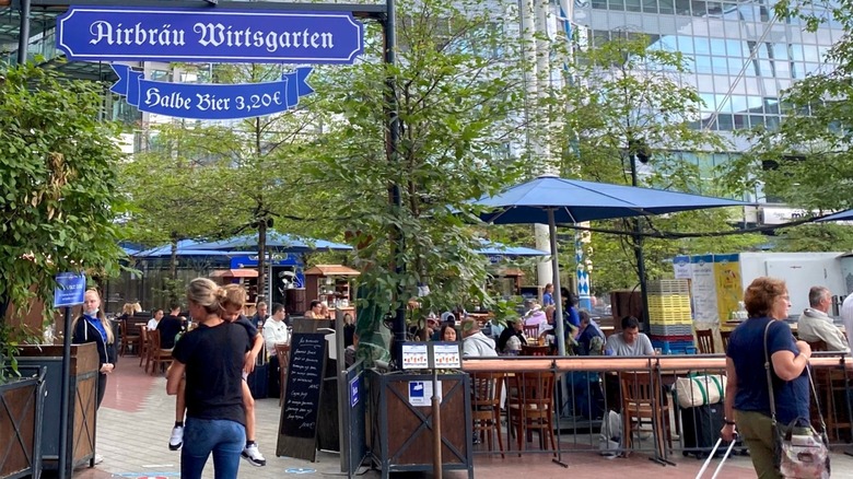 People walking around entrance to Airbrau beer garden